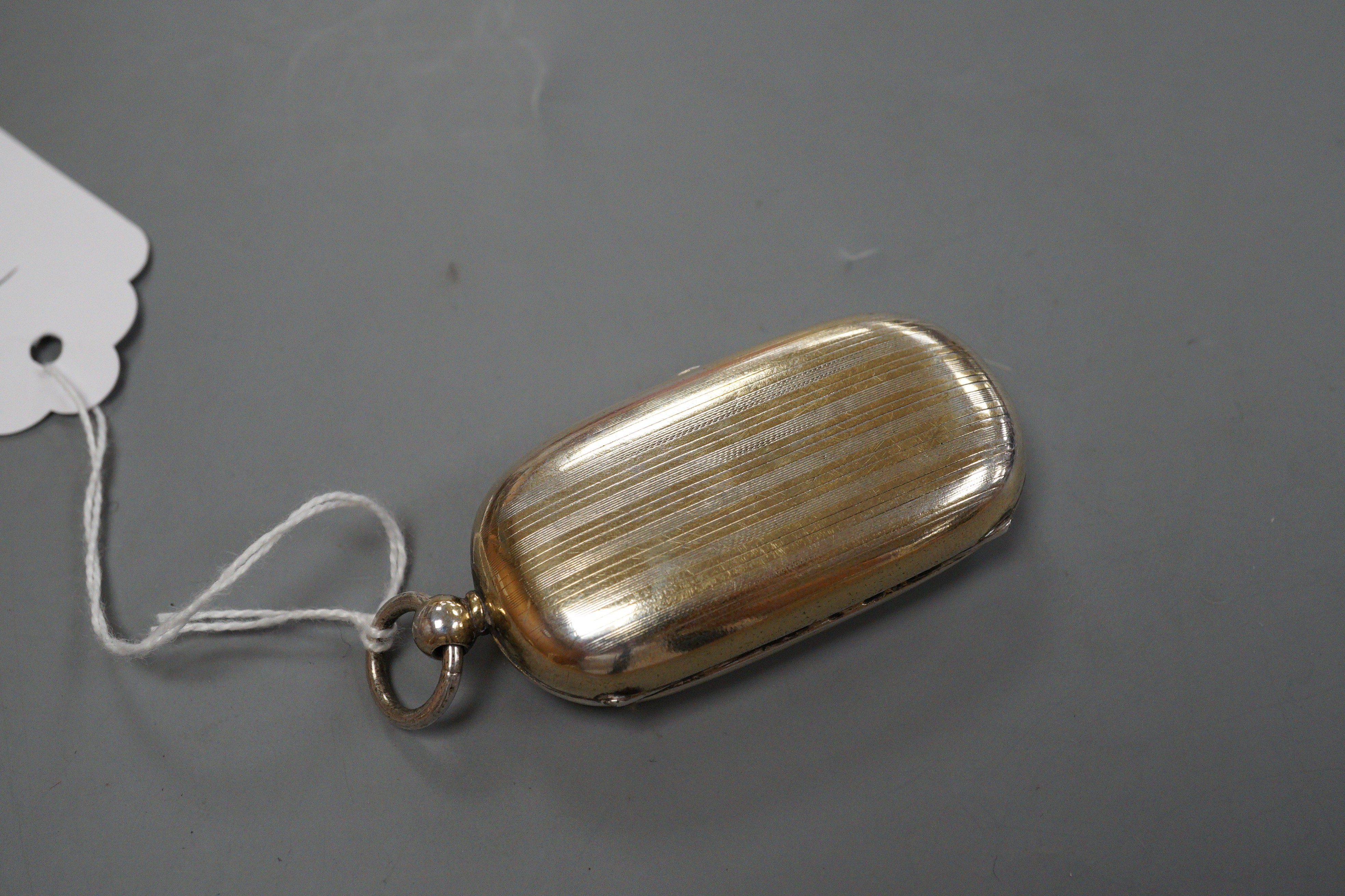 A George V silver silver gilt oval sovereign/half sovereign case, with engraved initials, Goldsmiths & Silversmiths Co Ltd, London, 1910 (gilding worn), 66mm.